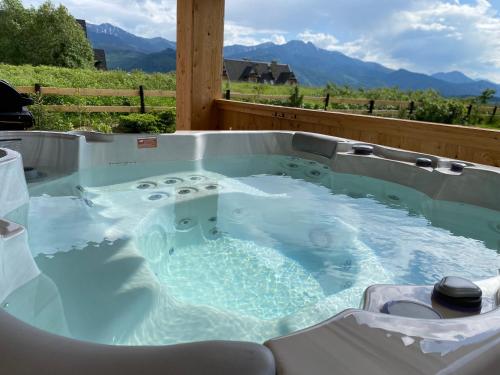 a jacuzzi tub with a view of the mountains at SOPA Zakopane in Zakopane