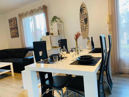 une table blanche avec des chaises noires et une salle à manger dans l'établissement Maison entière avec jardin - Comet Arena - Zenith, à Olivet
