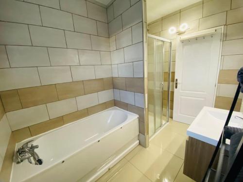 a bathroom with a tub and a shower and a sink at Maison entière avec jardin - Comet Arena - Zenith in Olivet