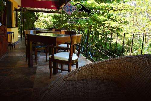 a restaurant with tables and chairs on a balcony at Los Susurros. Casa in Palenque