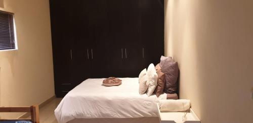 um quarto com uma cama com almofadas em Rietvlei Guesthouse Main House em Margate