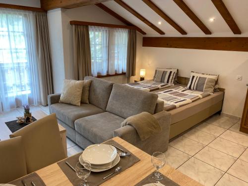 a living room with a couch and a bed at Apartments Arcadia in Saas-Grund