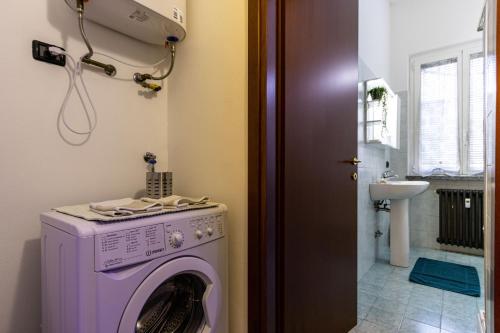una lavanderia con lavatrice viola di [Sweet Arona] Beautiful Apartment, Netflix - Wi-Fi ad Arona