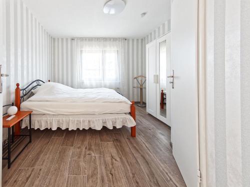 una camera con letto e pavimento in legno di Mein Strand Apartment a Scharbeutz