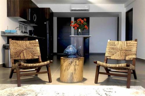 a living room with two chairs and a vase of flowers at Zona Comercial Nuevo Vallarta in Nuevo Vallarta