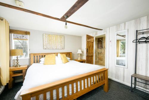 a bedroom with a large bed and two windows at The West Barn near Bath, sleeps 24 and 2 hot tubs in Bristol