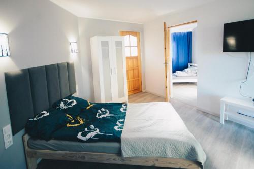 a bedroom with a bed with a blue blanket on it at Chatka in Stegienka