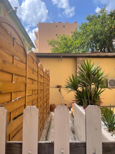 a wooden fence in front of a building with plants at Appartement 30m2 cosy avec terrasse in Menton