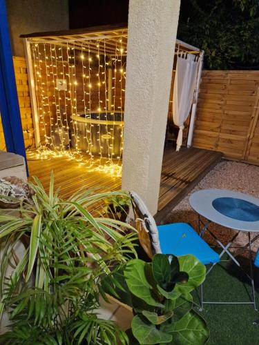 un patio avec un bouquet de lumières et de plantes dans l'établissement Chez Marie, à Bessan