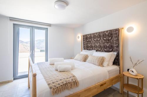 una camera da letto con un grande letto con una grande finestra di KEA 360 VILLAS- Apollos Alcove a Pisses