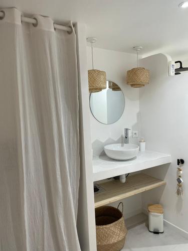 La salle de bains est pourvue d'un lavabo, d'un miroir et d'un rideau de douche. dans l'établissement Appartement 30m2 cosy avec terrasse, à Menton