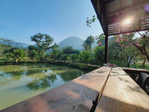 uma mesa de madeira com vista para um lago em Phukasa Valley Maesot 