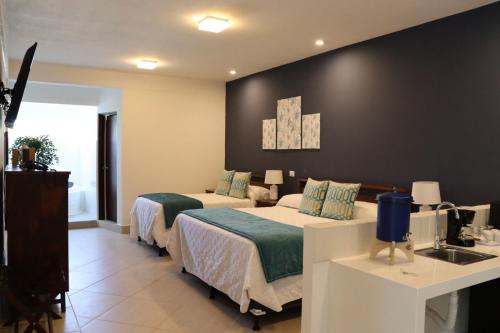 a hotel room with two beds and a sink at Hotel Gran Costa Azul in Puerto Santo Tomás de Castilla