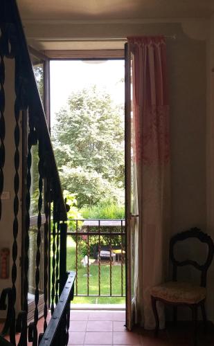 a door to a balcony with a view of a yard at Villa Amai in Bene Vagienna