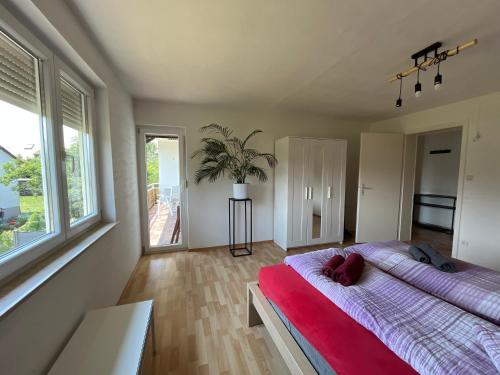 1 dormitorio con 1 cama grande con manta roja en Sonnige 3 Zimmer Wohnung mit schönem Balkon im Grünen, en Reutlingen