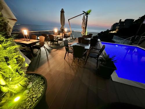 a balcony with tables and chairs and a swimming pool at Apart Lux Beciragic in Dobra Voda