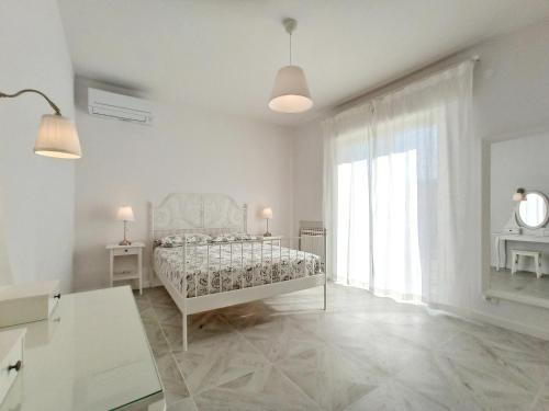 ein weißes Schlafzimmer mit einem Bett und einem großen Fenster in der Unterkunft Colombo 477 Auditorium in Civitanova Marche