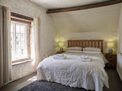 a bedroom with a bed with towels on it at Shire Cottage in Highpeak Junction
