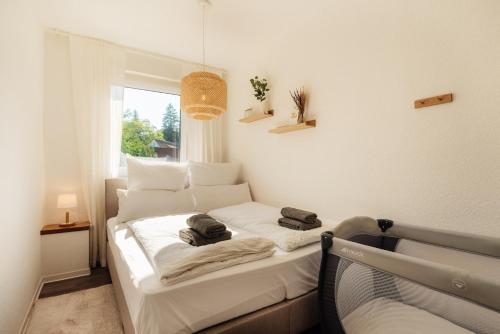 Un dormitorio con una cama blanca con toallas. en happyhome mitten im HARZ - direkte Wanderwege - Bachplätschern - Küche - Kinderfreundlich - Paare und Freunde en Elend