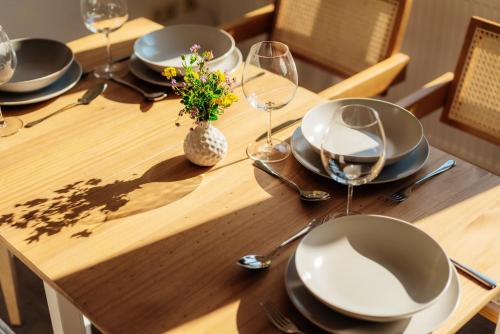 a wooden table with plates and glasses and a vase with flowers at happyhome mitten im HARZ - direkte Wanderwege - Bachplätschern - Küche - Kinderfreundlich - Paare und Freunde in Elend