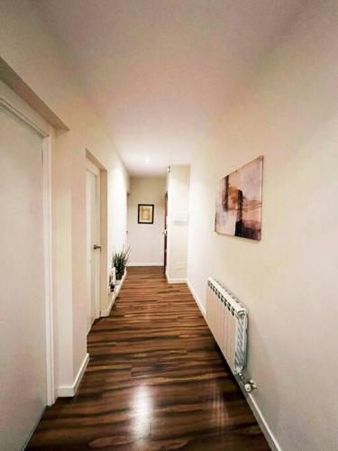 un corridoio di un appartamento con pavimenti in legno e pareti bianche di Leon Suites 4 - Enjoy Leon - Disfruta Leon a León