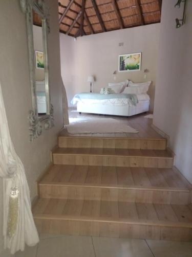a bedroom with a bed and some stairs at Ekuphumleni Holistic Healing Center in Johannesburg