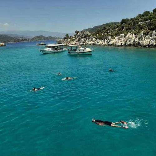 a group of people swimming in the water with boats at Manolyam suit 2 . 1+1 daire merkez in Kas
