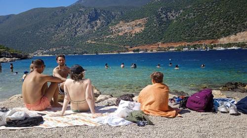 a group of people sitting on the beach at Manolyam suit 2 . 1+1 daire merkez in Kas