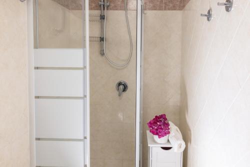 ein Badezimmer mit einer Dusche mit einer Vase aus Blumen auf einem Regal in der Unterkunft Villa La Natura x9 Whole villa with private parking in Sorrent