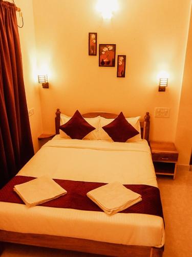 a bedroom with a large bed with towels on it at Casa De Menorah in Nerul