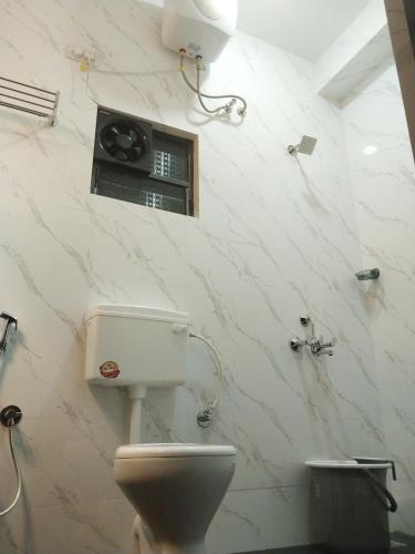 uma casa de banho com WC e uma coluna na parede em Casa De Menorah em Nerul