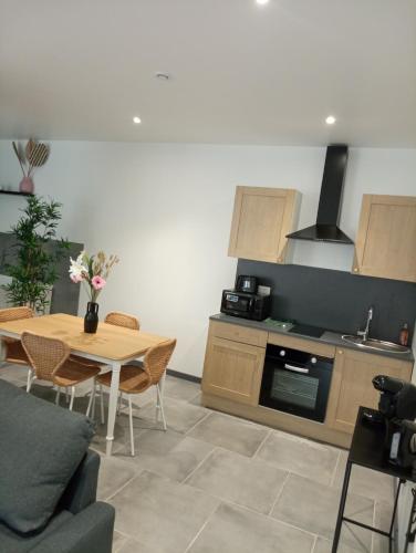 a living room with a table and a kitchen at Moment détente in Toul