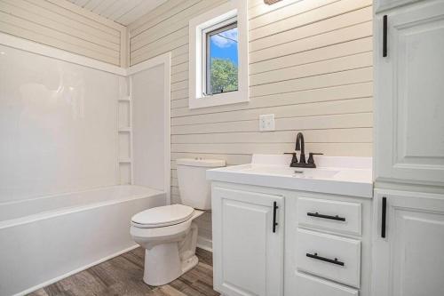 a white bathroom with a toilet and a sink at Pickleball Paradise in South Haven