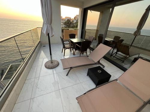 a balcony with a table and chairs and the ocean at Apart Lux Beciragic in Dobra Voda