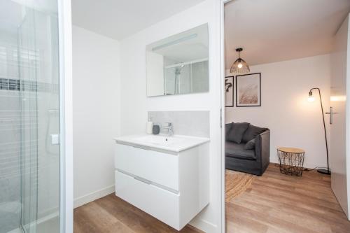 La salle de bains blanche est pourvue d'un lavabo et d'un miroir. dans l'établissement AmorAmor ~ T2 Romantique, à Vierzon