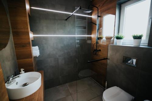 a bathroom with a shower and a toilet and a sink at Domki Beskidowelove Gierałtowiczki A in Zator