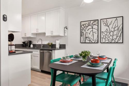 a kitchen with a black table and green chairs at East Village Arts District, King Suite with Sofa Bed NRP23-01221 in Long Beach