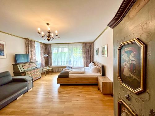 a bedroom with a bed and a couch in a room at Hotel Bergland in Grainau