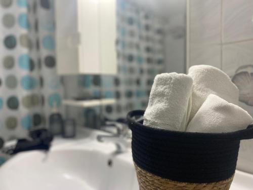 a basket of towels sitting on top of a bathroom sink at Oxo Kamara Apartment in Karpathos Town