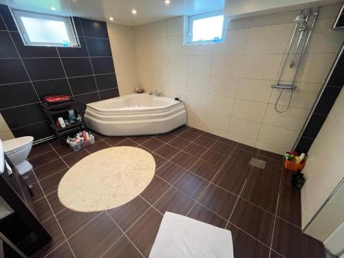 een badkamer met een bad, een toilet en een wastafel bij Villa Rydholm 15 minutes from Gothenburg Center in Göteborg