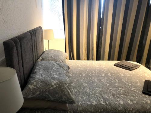 a bedroom with a bed with a pillow and a window at AC Lounge 125 in Rochford