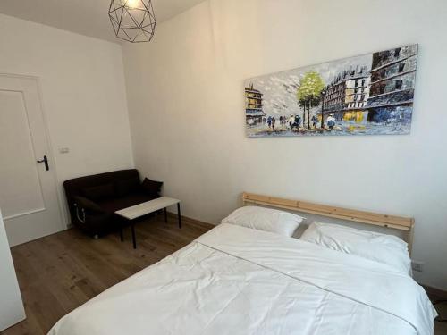 - une chambre avec un lit blanc et une chaise dans l'établissement Scilla Domus - Appartamento a Torino - S. Rita, à Turin