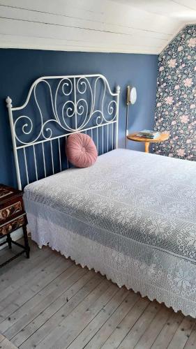 1 dormitorio con cama y pared azul en Lunden, en Vittaryd