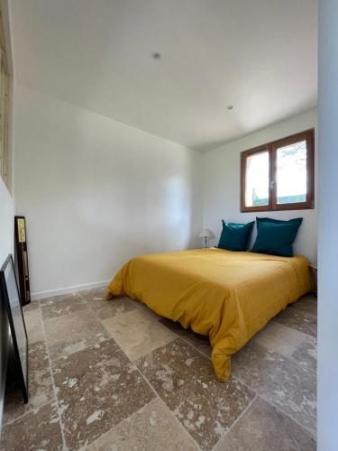 - une chambre avec un lit doté d'une couverture jaune et d'oreillers bleus dans l'établissement L'Echo de la nature, à Sasseville