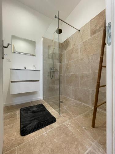 La salle de bains est pourvue d'une douche et d'un tapis noir. dans l'établissement L'Echo de la nature, à Sasseville