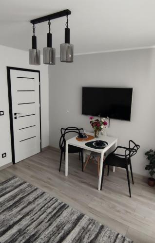 a living room with a table and a tv at Kraken Apart in Kołobrzeg