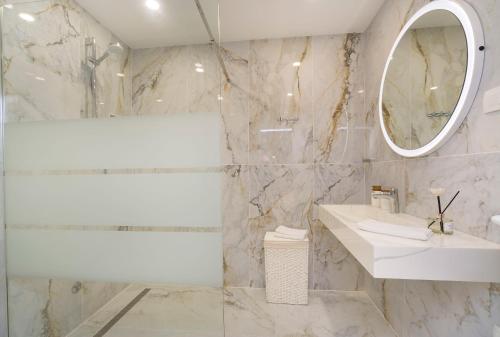 Baño blanco con lavabo y espejo en Apartments Marija, en Brna