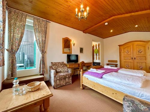 a bedroom with a large bed and a desk at Hotel Bergland in Grainau