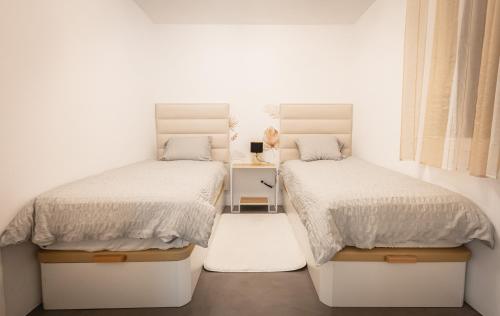 マルベーリャにあるApartment Puerto Banus Marbellaの白い壁の客室内のベッド2台