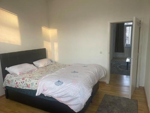 1 dormitorio con 1 cama grande con sábanas blancas en Bruxelles, en Bruselas
